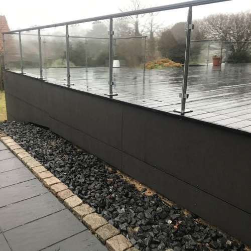 hævet træterrasse med glasgelænder