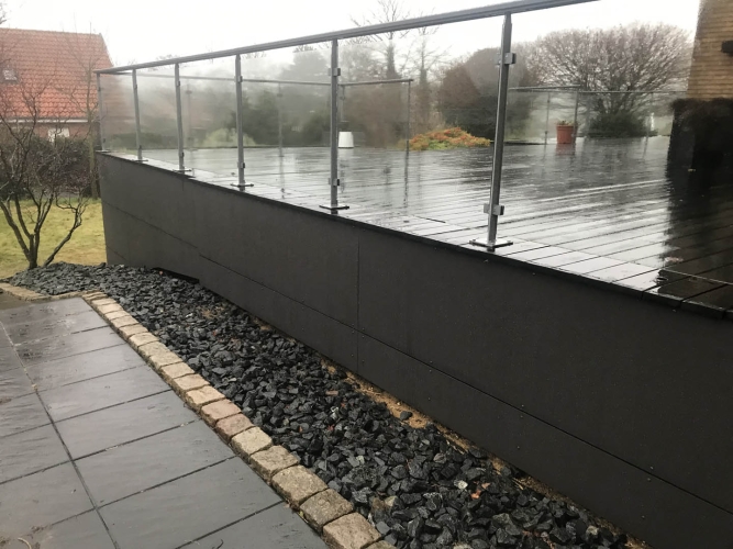hævet træterrasse med glasgelænder